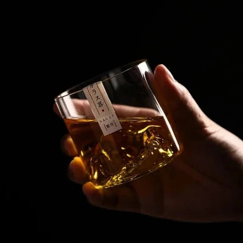 Un verre à whisky qui tient parfaitement en main, mettant en valeur son design unique avec un relief de montagne sculpté à l'intérieur.
