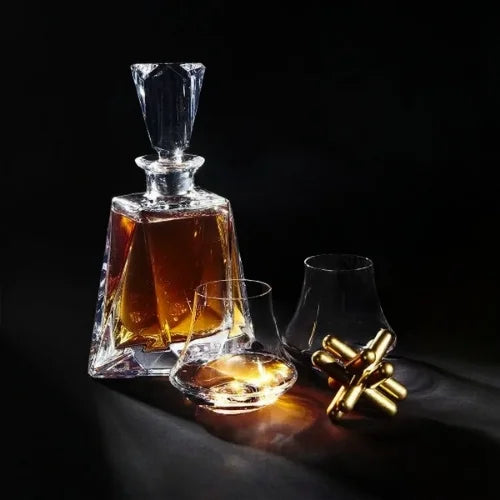 Homme savourant un whisky dans un verre de dégustation design, en contre-jour avec vue floue sur l'extérieur.
